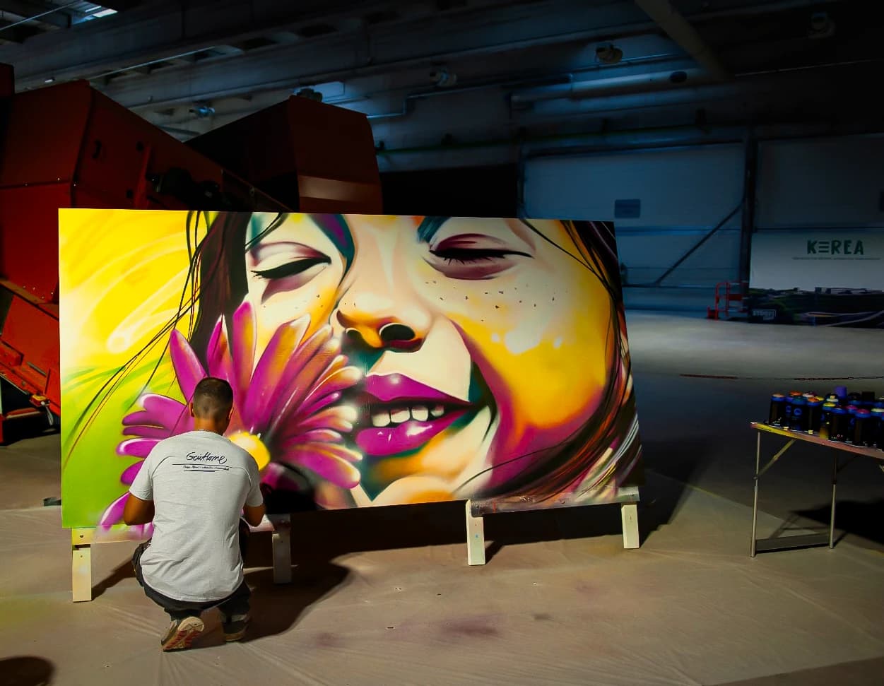 Artiste peignant un portrait coloré lors d'un événement live painting au centre KEREA